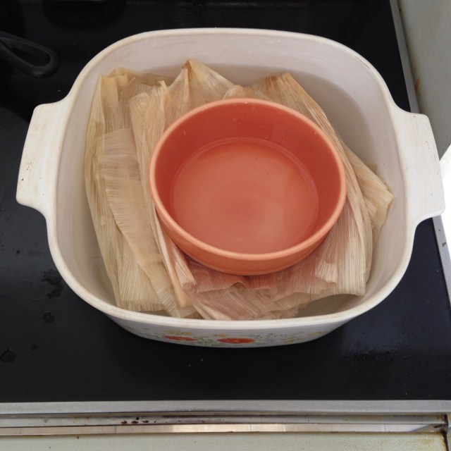 You can put a bowl or something else heavy on top of the corn husks to make sure they stay submerged.