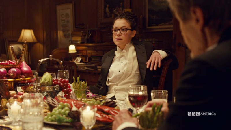 Cosima is leaning back in her tux looking like she owns the place