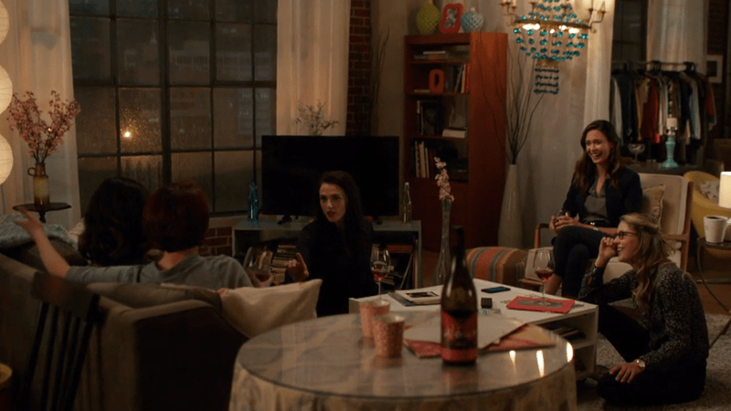 Alex, Maggie, Lena, Kara, and Sam sit in Kara's apartment laughing
