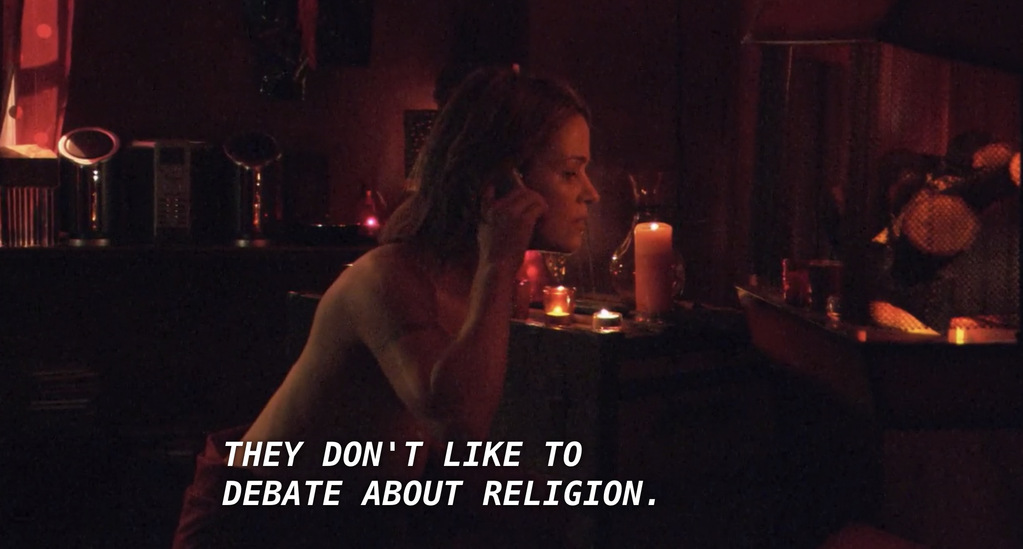 Alice is talking on the phone in a room surrounded with candles. Helena says through the phone, referring to her research about vampires, "they don't like to debate about religion."