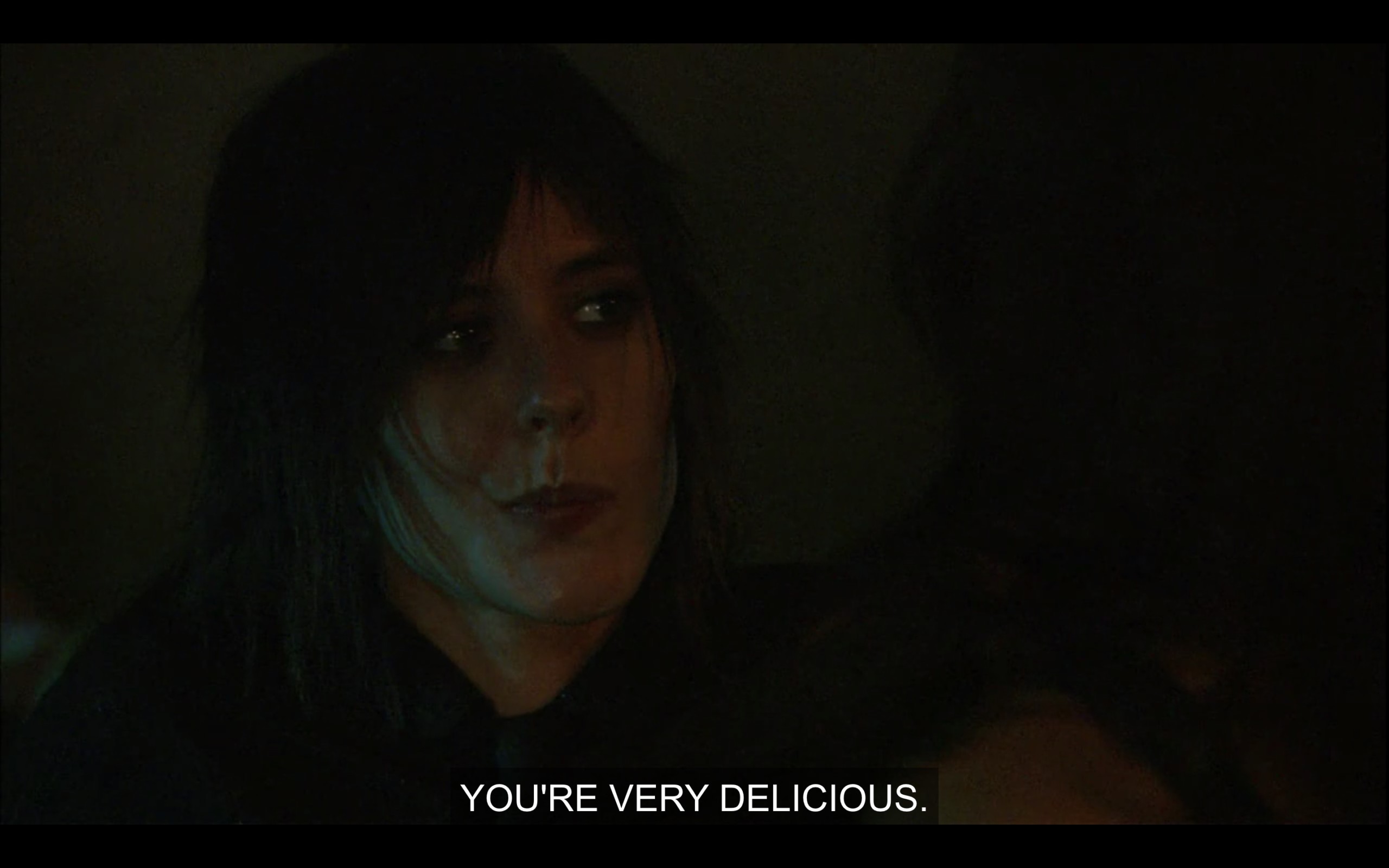 Shane, wearing all black, purses her lips and says, "You're very delicious."