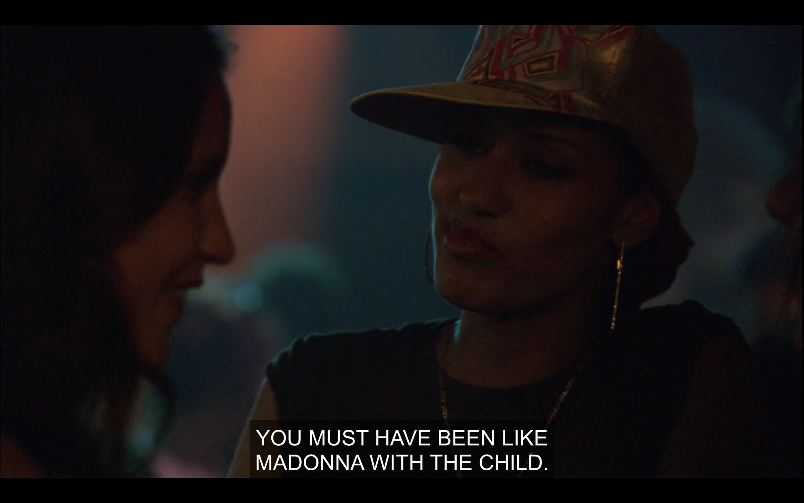 Dimly lit shot of Papi, wearing hoop earrings and hat. "You must have been like Madonna with the child."