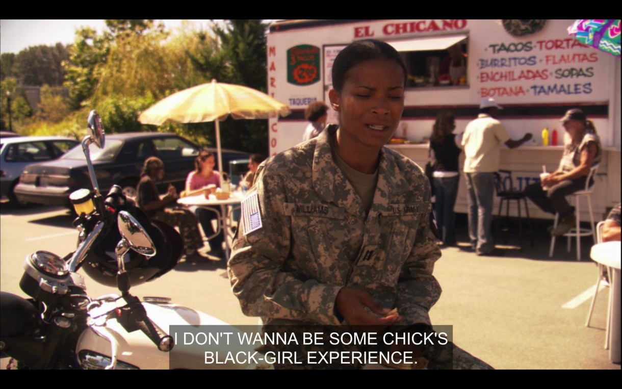 Tasha in full military uniform. Her bike is parked behind her. We're outside, it's sunny. There's a taco truck in the background. Tasha is talking to Papi saying "I don't want to be some chick's Black Girl Experience."