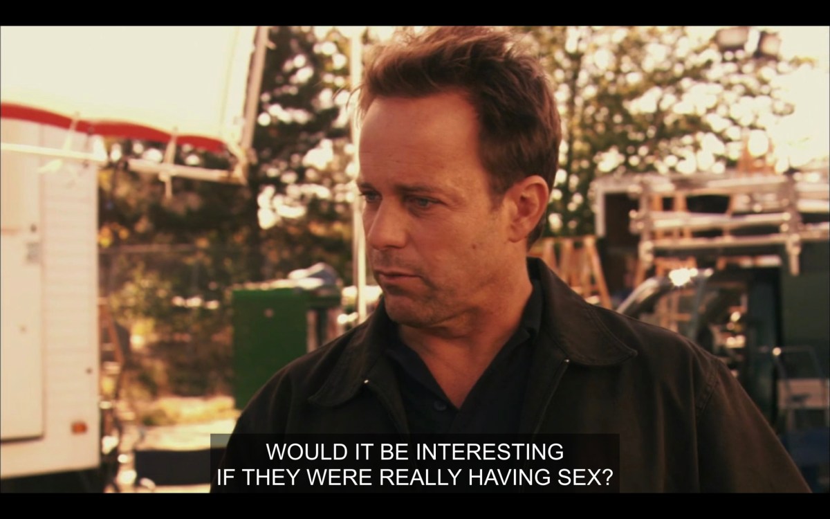 A man with short brown hair, wearing a black jacket. "Would it be interesting if they were really having sex?"
