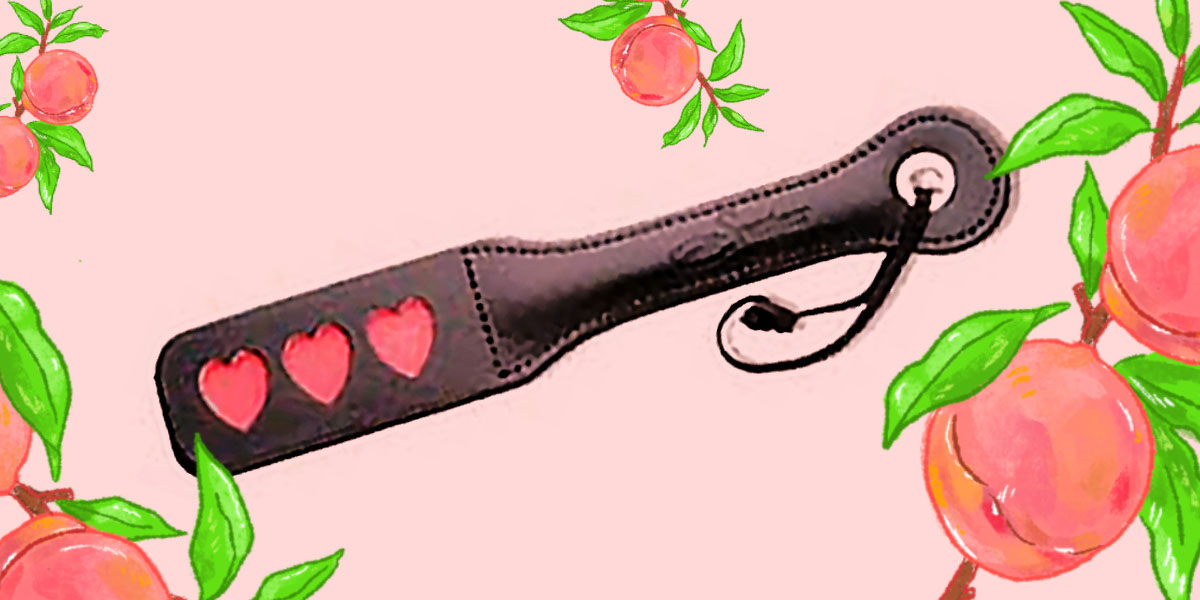 Leather Heart Impression Slapper - a black paddle with three red hearts on the paddle area