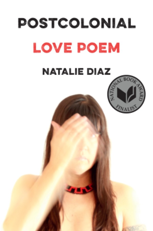 a book cover with a white background and in black text at the top "Postcolonial" in red "Love Poem" and in black again "Natalie Diaz" followed by a photo of Diaz with long hair and a beaded necklack, and a blurred hand passing in front of her face.