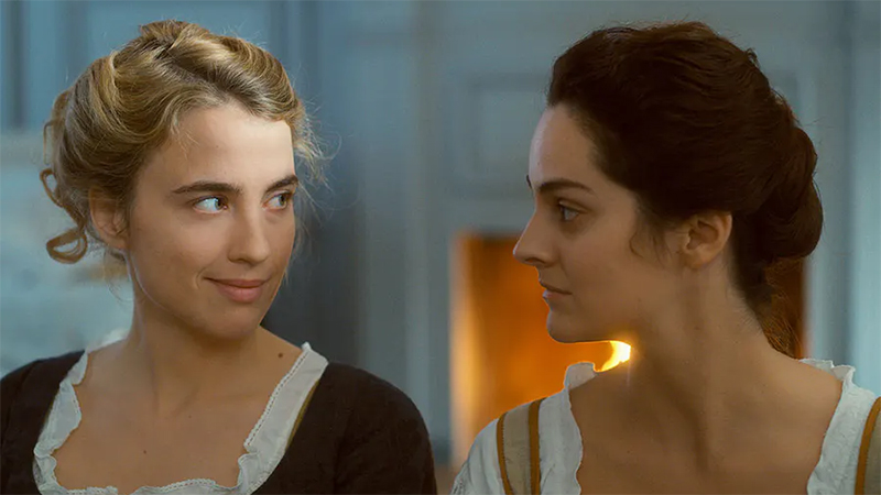 Marianne and Héloïse share a look in front of the fireplace