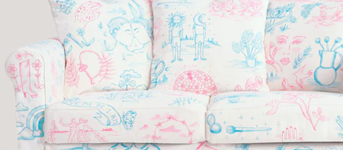 A close up of the trans pride couch, in pink and blue colors depicting line drawings of various images