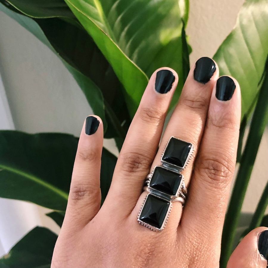 A person shows off a silver and black ring.