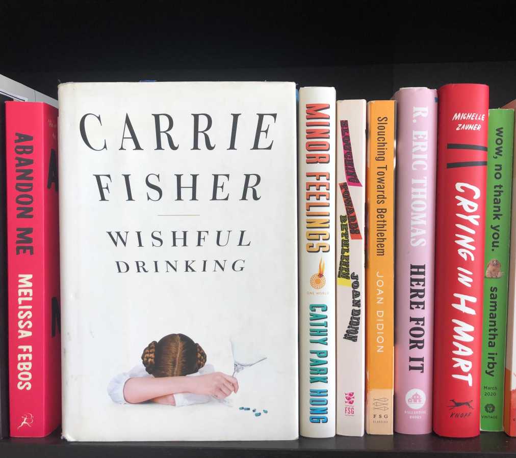 a copy of carrie fisher's wishful drinking on a bookshelf