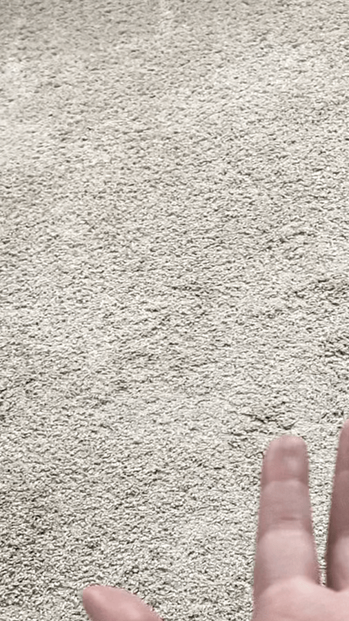A gif shows a.Tony's open palm. They then fold in all but their pointer and middle fingers to make a "come hither" motion. A beige carpet and a black cord are in the background.