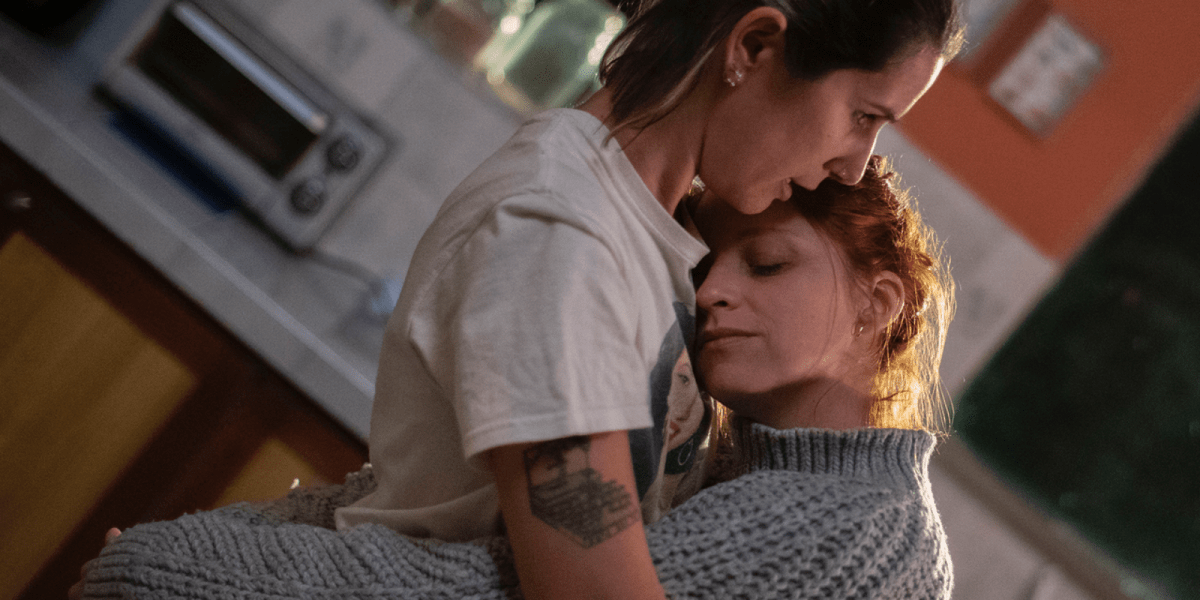 A couple comforting each other in the kitchen