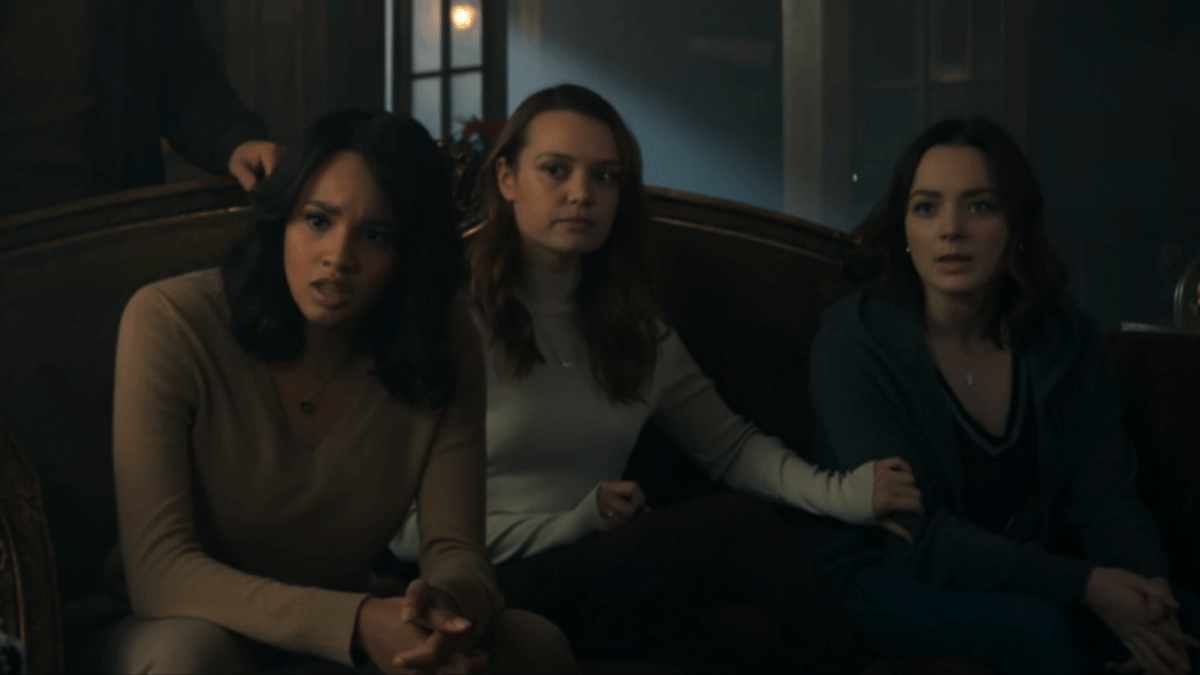 Abigail, Tally, and Scylla sit on the couch and look pissed; Tally has a hand on Scylla's arm