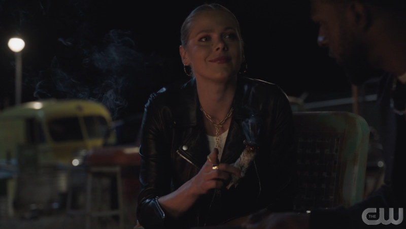 Isobel wears a leather jacket and holds sage