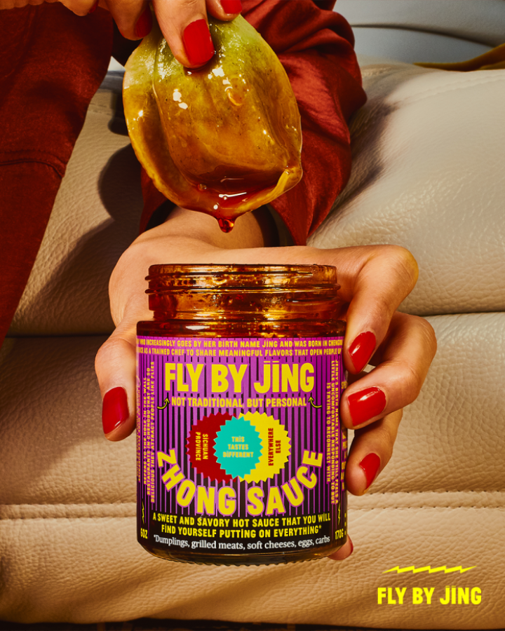 an image of a delicious dumpling being dipped into fly by jing's zhong sauce by femme, nail-polish decorated hands