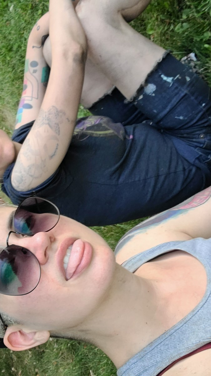 sadie and nico sitting in the grass, looking super gross and dusty from doing home reno