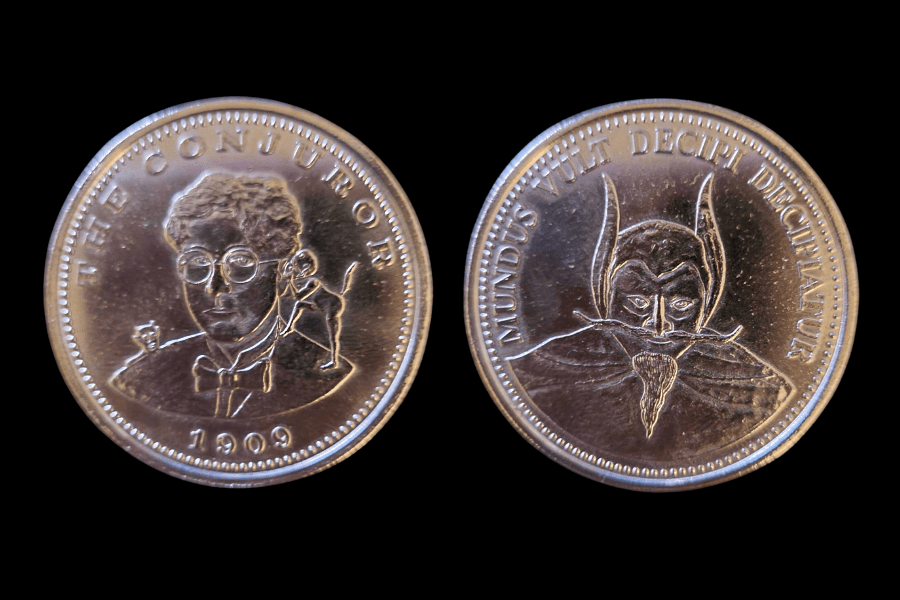 the coin described in the paragraph above with the magician on one side in glasses and a bowtie with a devil whispering in his ear, and on the other side is a magician type in a skullcap and horns.