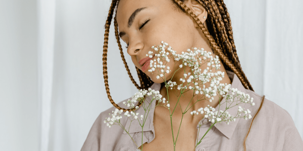 Black person with braids holding Baby's breath.