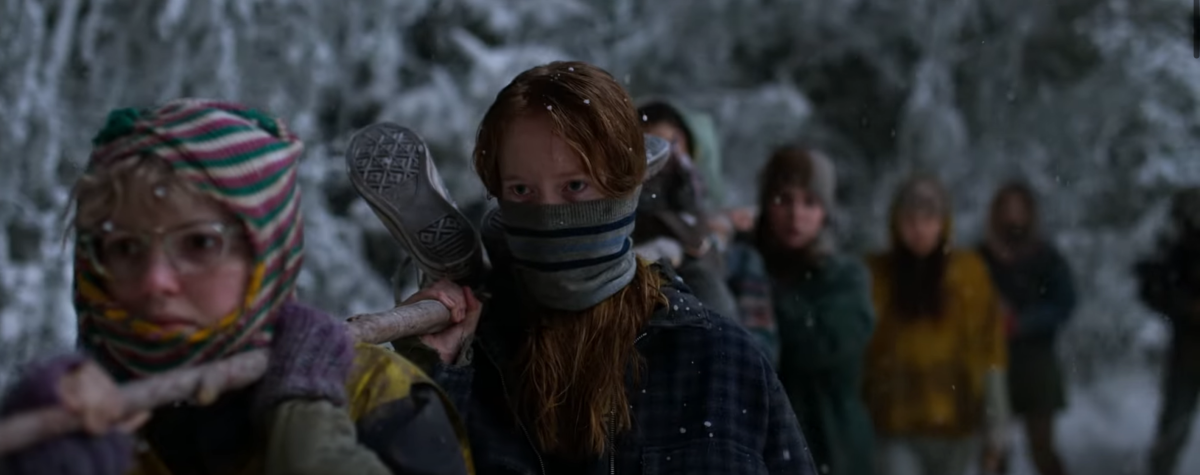 Misty and Van and some other girls carry a large stick in the snowy woods and sneakers pop up, suggesting a human body is tied to the stick in the Yellowjackets season 2 trailer.