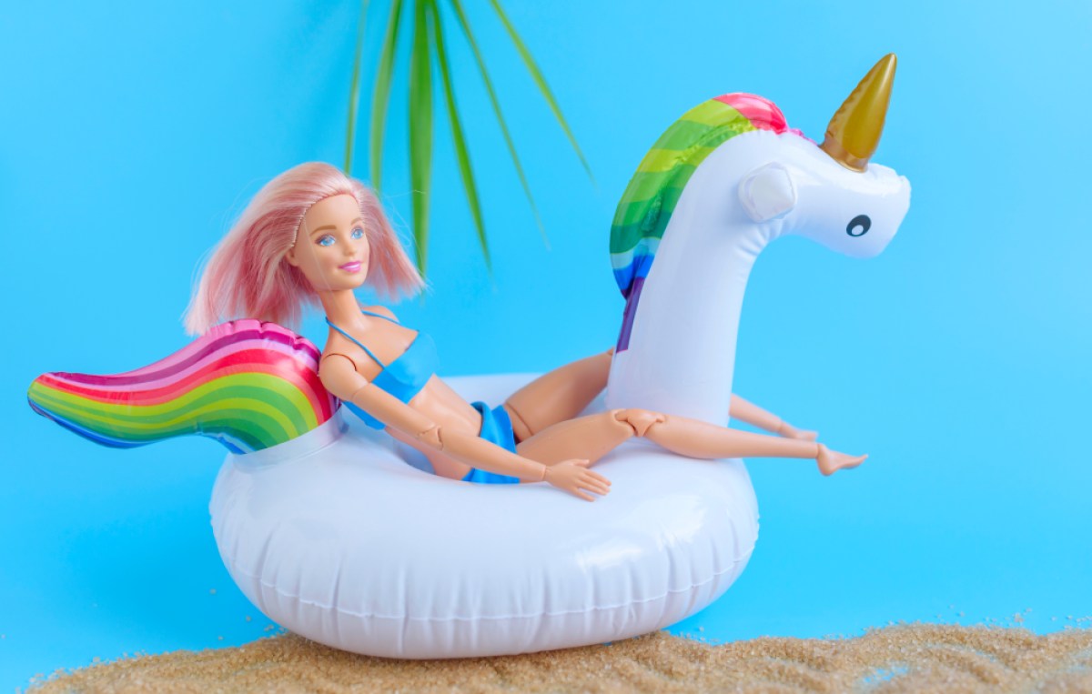 Barbie with pink hair on an unicorn pool floatie
