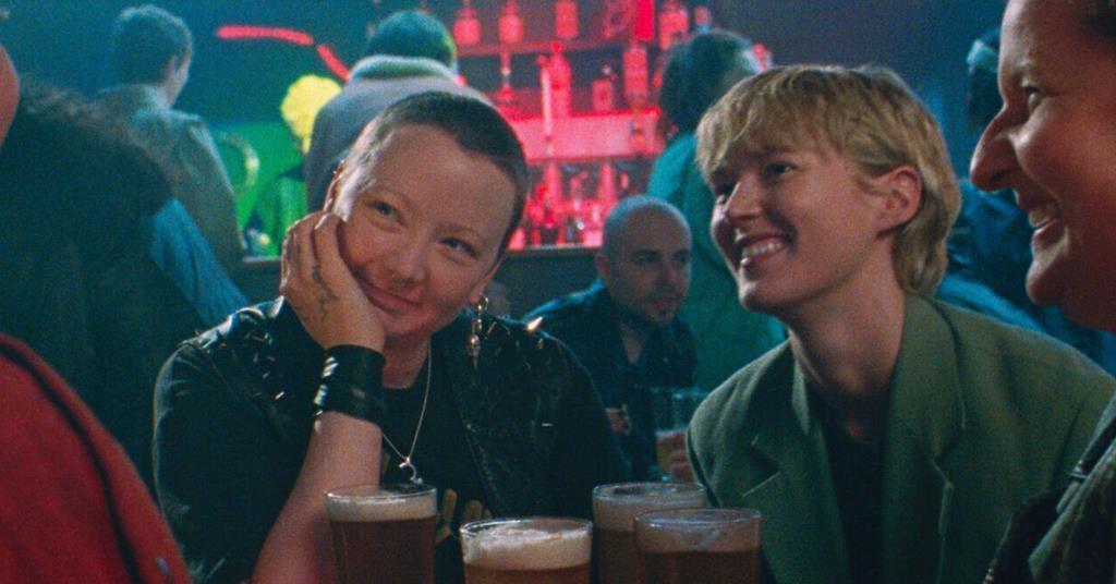 two lesbians laughing together in a bar