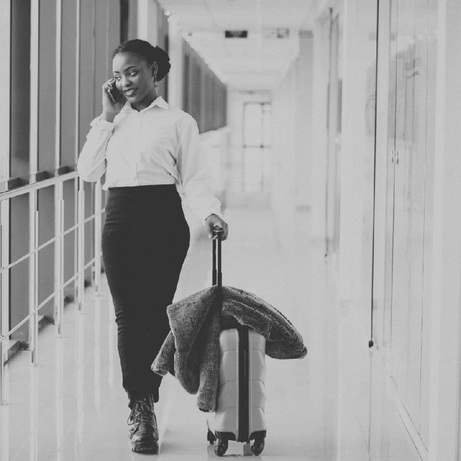 a GIF of a Black woman wheeling a suitcase down an airport hallway. i pink and orange masquerade mask appears over her eyes followed by confetti because Leo's bad advice for a new year's resolution for their zodiac sign is to lie and create personas
