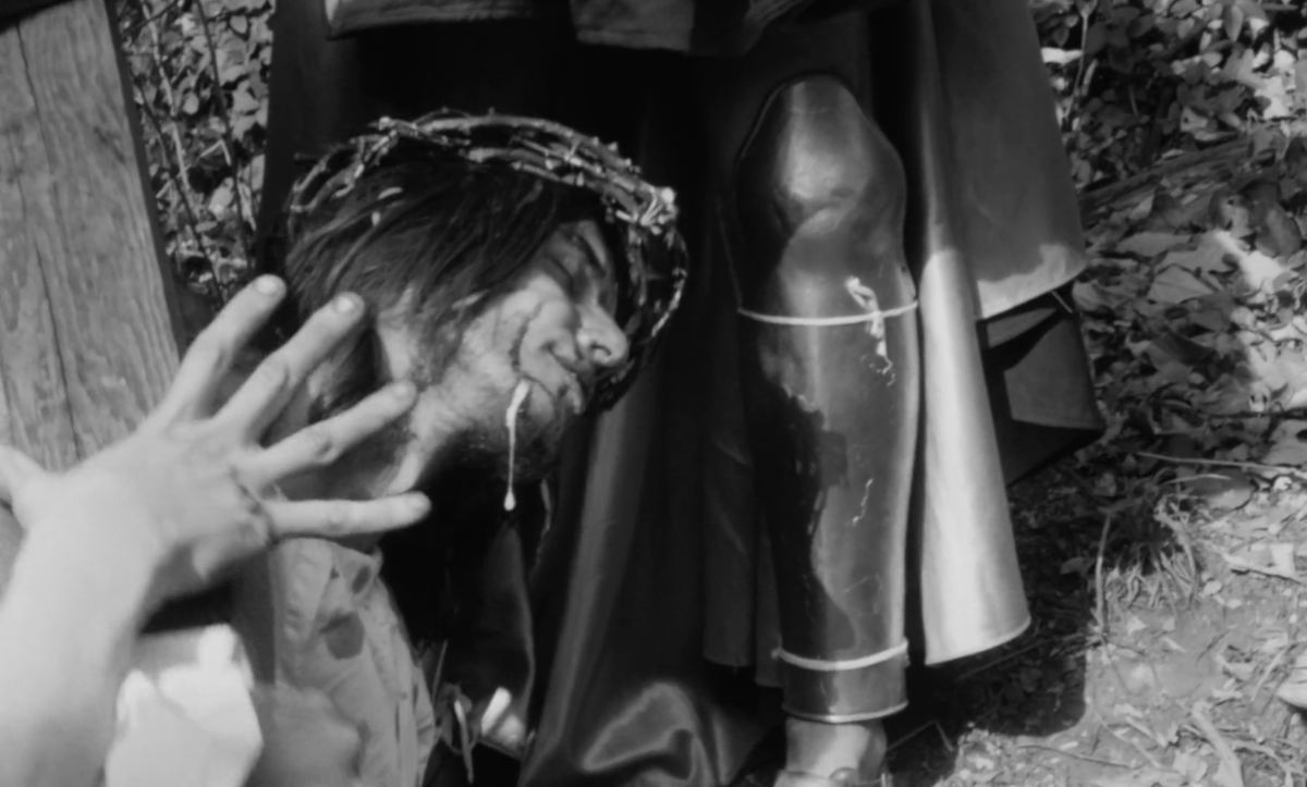 Jesus bleeds carrying the cross with spit dripping down his beard